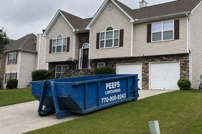 Residential Cleanout Dumpster Rental in Atlanta Blue dumpster labeled 'Peeps Containers' sits in the driveway of a beige two-story house with stone veneer and white garage doors.